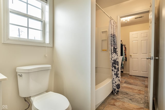 bathroom featuring shower / tub combo with curtain and toilet