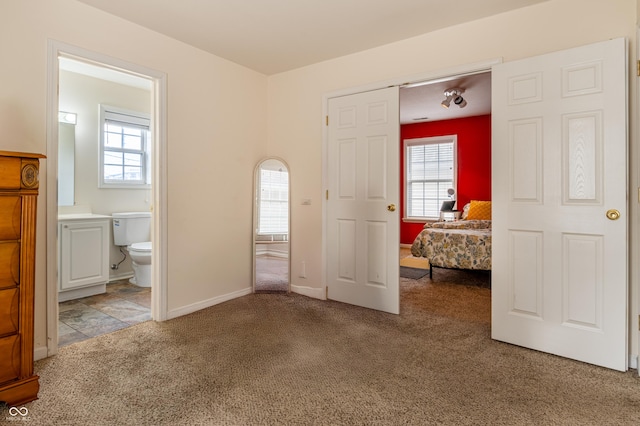 unfurnished bedroom with carpet flooring and ensuite bathroom