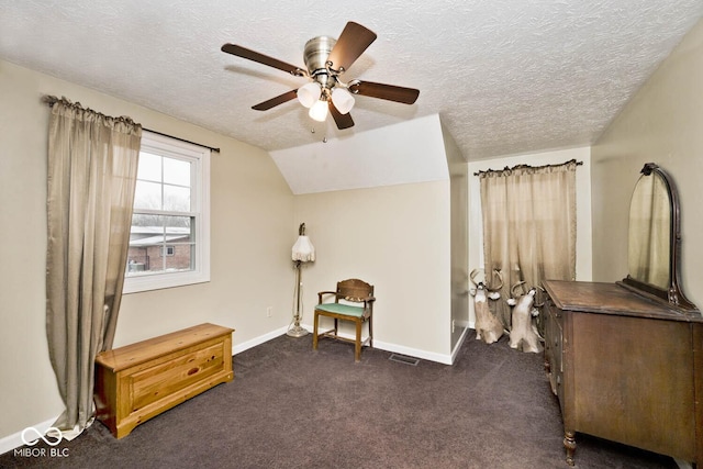 living area with ceiling fan, dark carpet, a textured ceiling, and vaulted ceiling