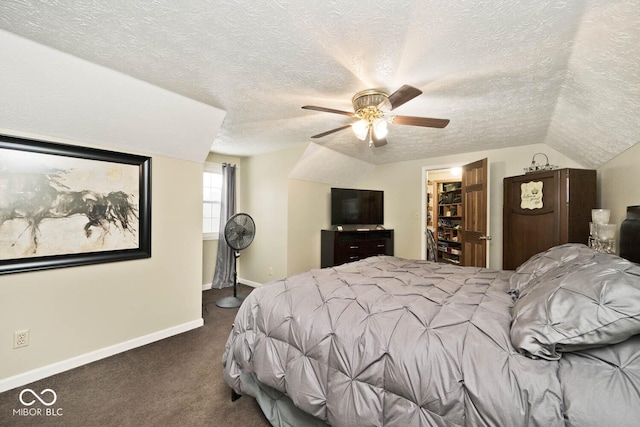 carpeted bedroom with a textured ceiling, vaulted ceiling, and ceiling fan