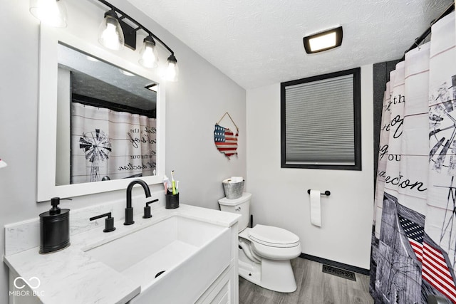 bathroom with a textured ceiling, toilet, hardwood / wood-style flooring, vanity, and a shower with shower curtain