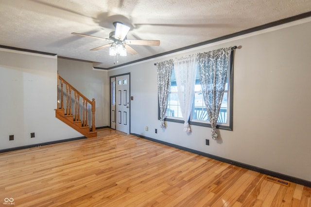 entrance foyer with light wood-type flooring, a textured ceiling, ceiling fan, and ornamental molding