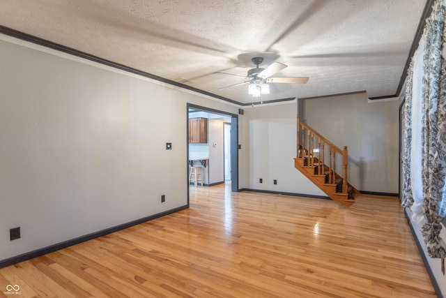 empty room featuring light hardwood / wood-style floors, a textured ceiling, ceiling fan, and ornamental molding