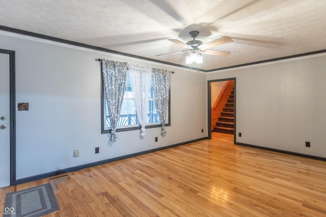 spare room featuring light wood-type flooring, crown molding, a textured ceiling, and ceiling fan