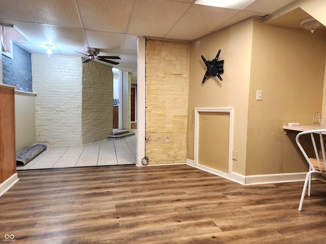 interior space featuring ceiling fan, a drop ceiling, and hardwood / wood-style flooring