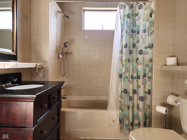 full bathroom with tile walls, shower / tub combo with curtain, vanity, and plenty of natural light