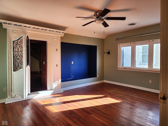 spare room featuring dark hardwood / wood-style flooring, vaulted ceiling, and ceiling fan