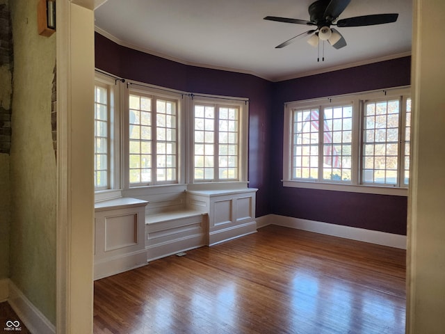 spare room featuring ceiling fan, wood-type flooring, and crown molding