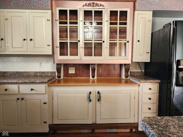 kitchen featuring decorative backsplash and black fridge