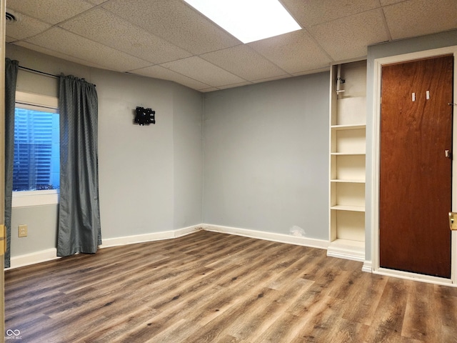 empty room featuring a paneled ceiling and hardwood / wood-style flooring