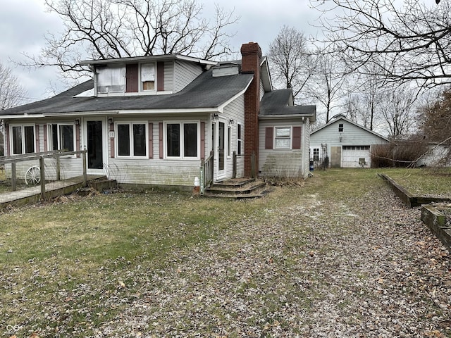 view of front of property with a garage, an outdoor structure, and a front lawn