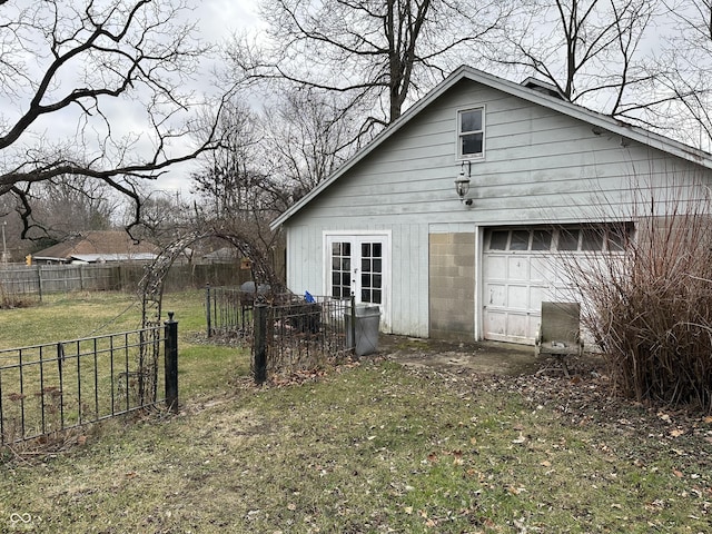 rear view of house with a garage, an outdoor structure, and a lawn