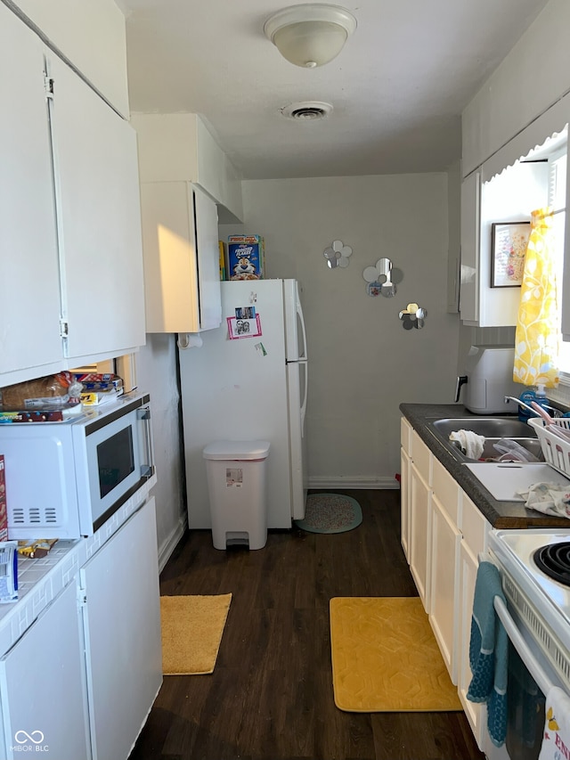 kitchen featuring white cabinets, white appliances, dark wood-type flooring, and sink