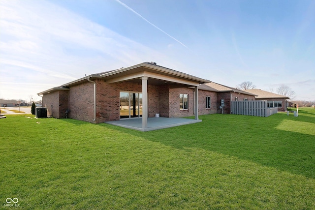 rear view of property featuring a yard, a patio, and cooling unit