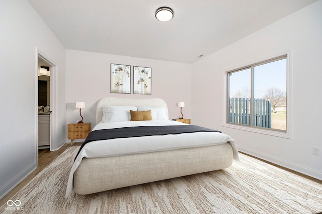 bedroom featuring baseboards and wood finished floors