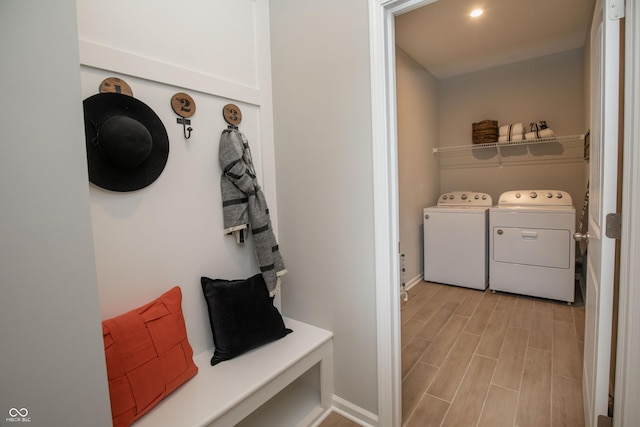 mudroom with light wood-type flooring and washing machine and clothes dryer