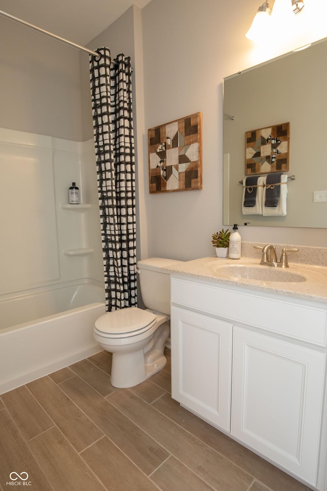 full bathroom featuring hardwood / wood-style flooring, shower / bath combo, toilet, and vanity