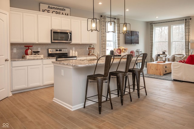 kitchen with white cabinets, a healthy amount of sunlight, and appliances with stainless steel finishes