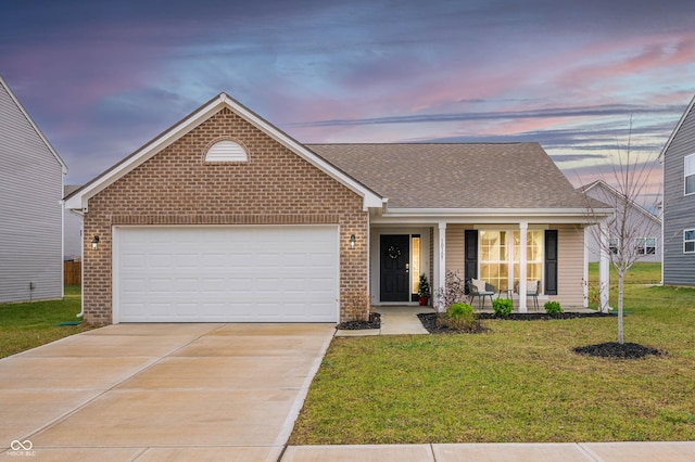 view of front of house featuring a garage, covered porch, and a yard