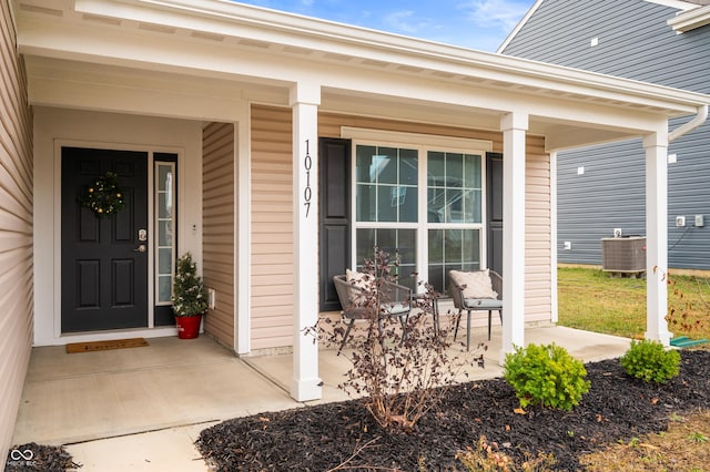 view of exterior entry featuring a porch and central air condition unit