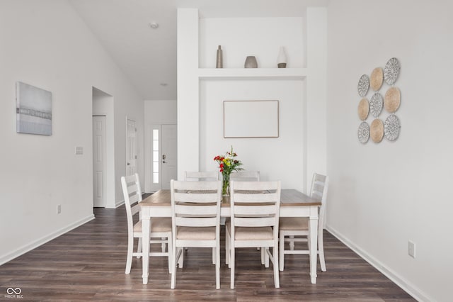 dining space with lofted ceiling and dark wood-type flooring