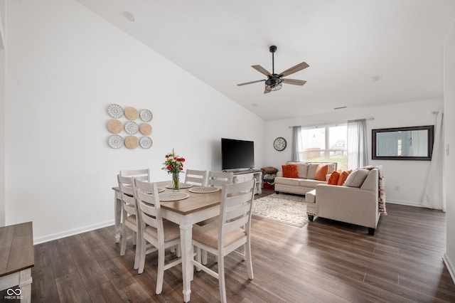 dining space with ceiling fan, dark wood-type flooring, and vaulted ceiling