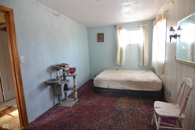 bedroom featuring wood walls and carpet