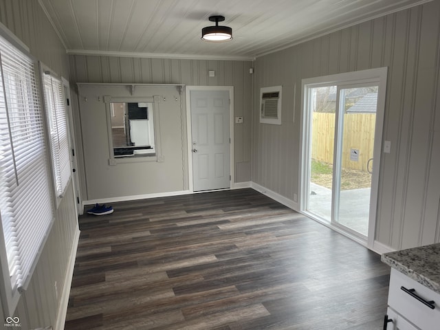 empty room with an AC wall unit, dark hardwood / wood-style flooring, and ornamental molding