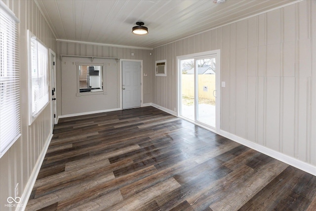 spare room featuring a wall mounted AC, dark hardwood / wood-style flooring, and ornamental molding