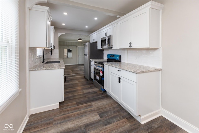 kitchen featuring stainless steel appliances, white cabinetry, tasteful backsplash, and sink