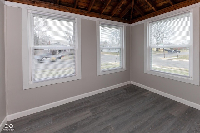 unfurnished room with vaulted ceiling with beams, dark hardwood / wood-style floors, plenty of natural light, and wooden ceiling