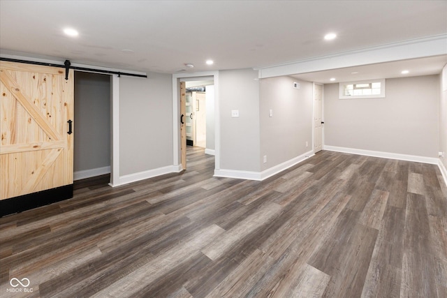 basement featuring dark hardwood / wood-style floors and a barn door