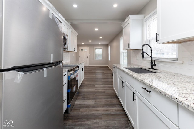 kitchen featuring white cabinetry, sink, dark wood-type flooring, stainless steel appliances, and backsplash