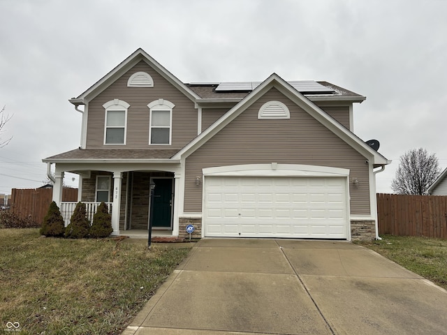 view of property with a front lawn, covered porch, a garage, and solar panels