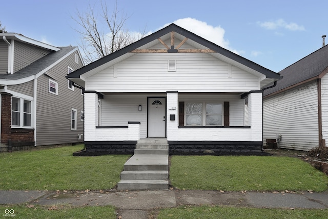 bungalow-style home featuring covered porch and a front lawn