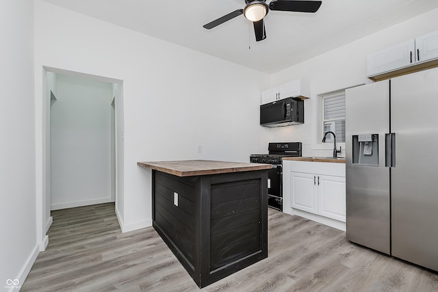 kitchen with butcher block countertops, white cabinets, and black appliances