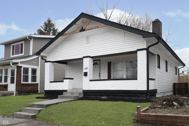 view of front of home featuring covered porch and a front lawn