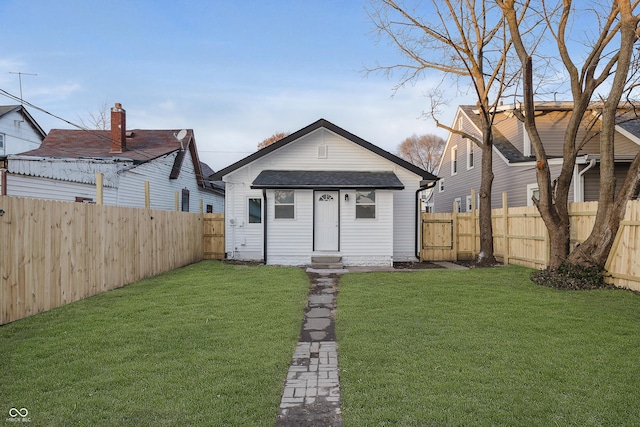 rear view of property with an outdoor structure and a lawn