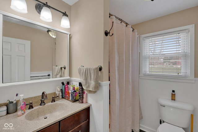 bathroom featuring a shower with curtain, vanity, and toilet