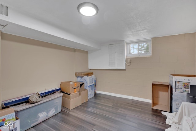 basement featuring a textured ceiling and dark wood-type flooring