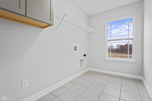 washroom featuring washer hookup, cabinets, light tile patterned floors, and electric dryer hookup