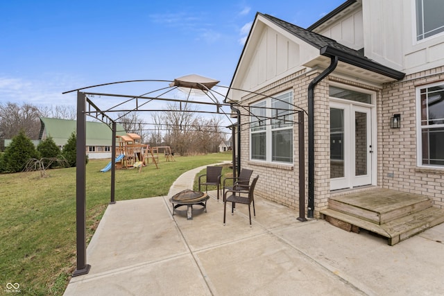 view of patio featuring a playground and a fire pit