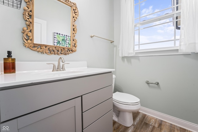 bathroom featuring wood-type flooring, toilet, and vanity