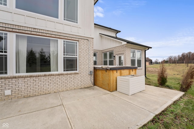 exterior space with a hot tub and a patio