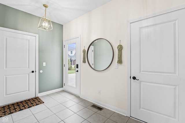 tiled foyer with an inviting chandelier