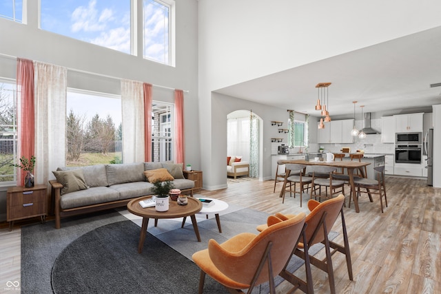 living room with a high ceiling and light wood-type flooring