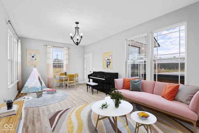 living room with a notable chandelier and light wood-type flooring