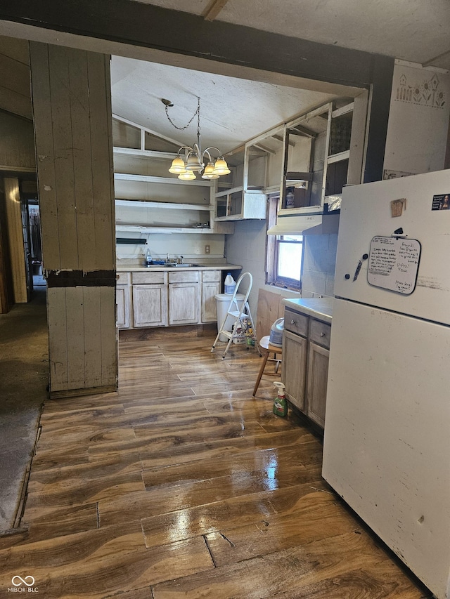 kitchen with white fridge, an inviting chandelier, dark hardwood / wood-style flooring, and decorative light fixtures