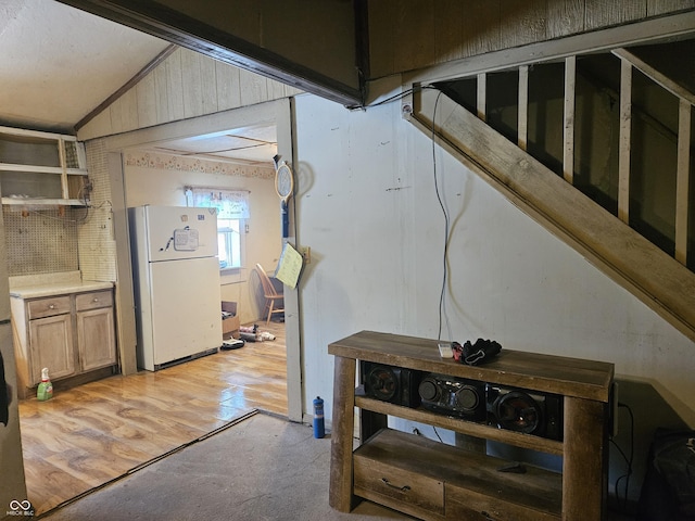 hallway featuring lofted ceiling and light hardwood / wood-style floors