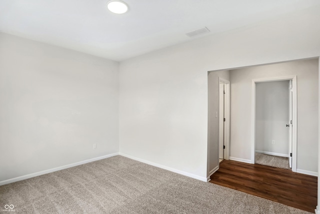 spare room featuring dark colored carpet